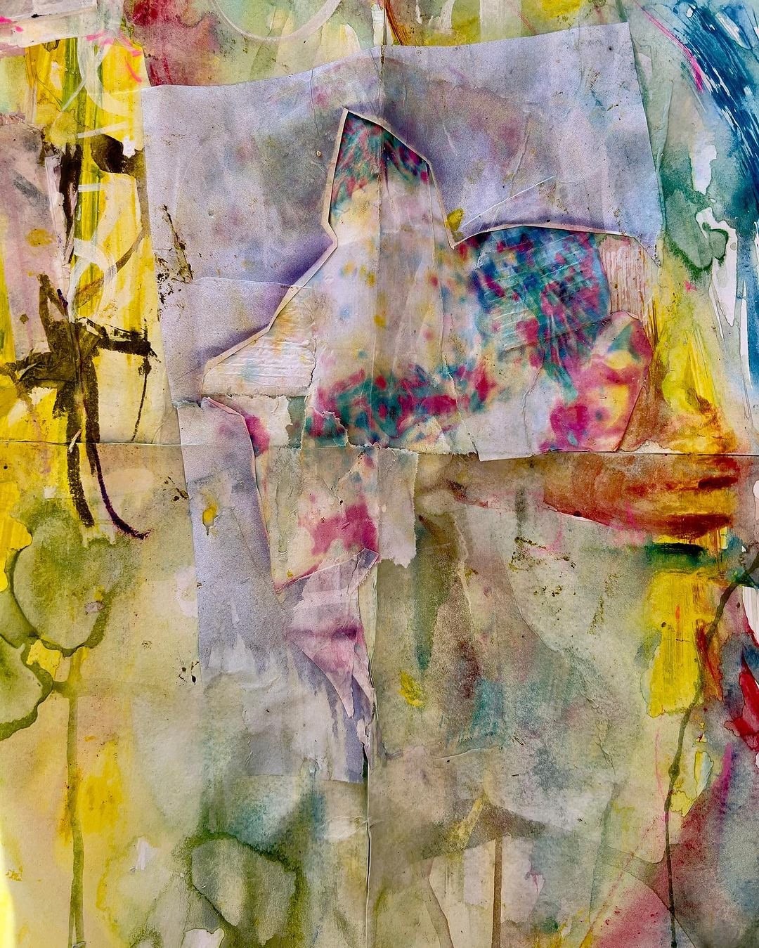 Abstract collage artwork with torn and folded paper textures, watercolor washes, and layered pigments in yellow, green, lavender, and muted reds. A star-like cutout form near the center creates dimensional tension, surrounded by organic stains and brush marks that suggest a sense of decay, rebirth, and movement.