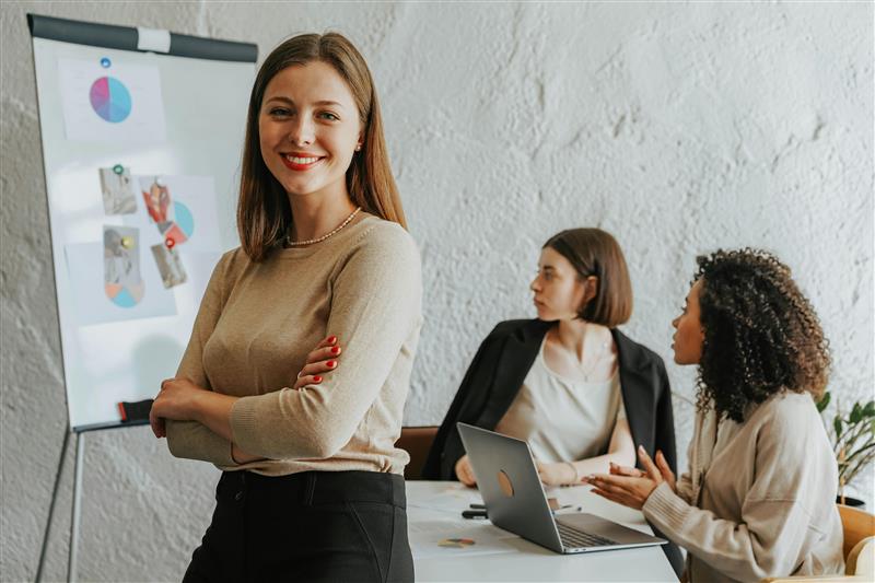 A person reviews a resume labeled "Olivia Wilson" on a clipboard placed on a round, light brown table beside a cup of coffee.