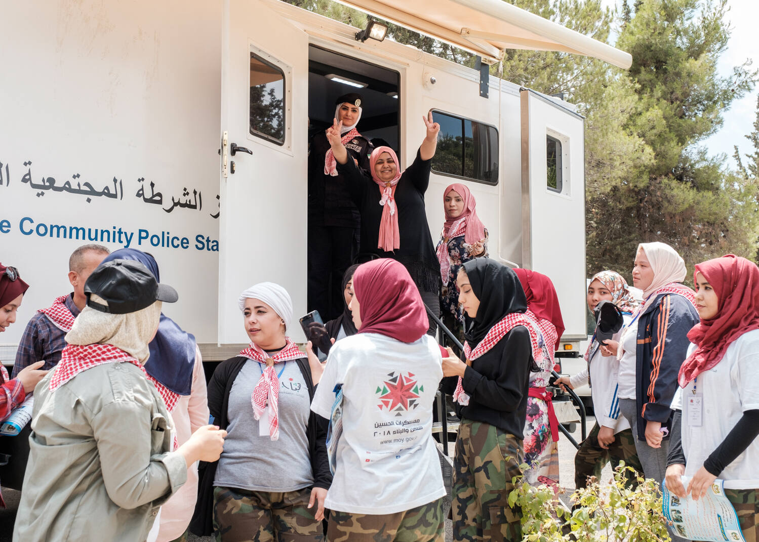 A group of young women outside a mobile police station at a police-community engagement event in Jordan. 