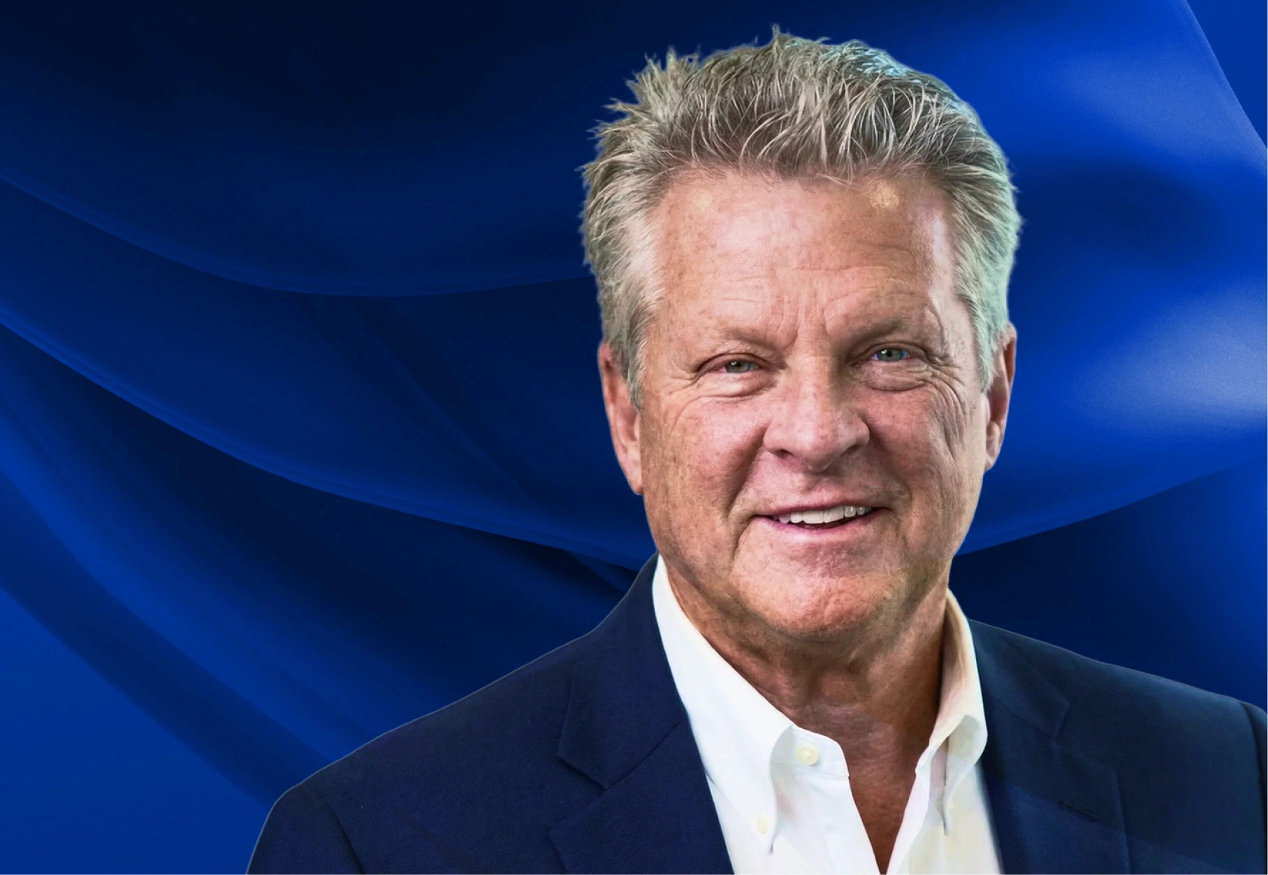 Two men discuss a project while standing at a laptop in an office.