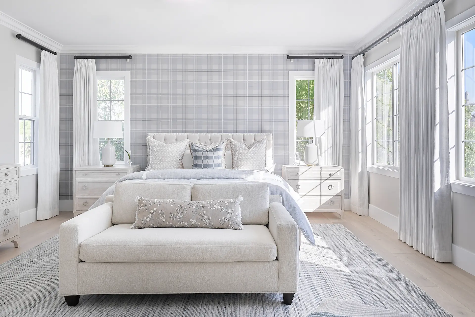 Expansive view of the primary bedroom, highlighting the bed, decor, and room layout in the Irvine Contemporary Coastal Remodel. Photo by Todd Huge.