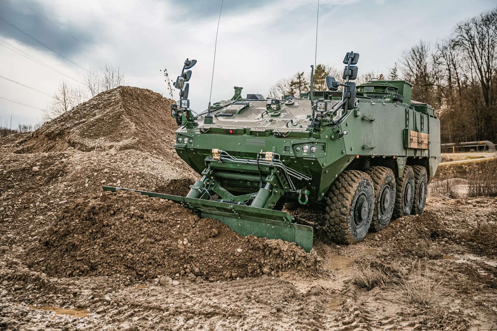 Piranha IV wheeled armoured vehicle with GCS Dozer Blade pushing soil during combat engineering and obstacle clearance operations.