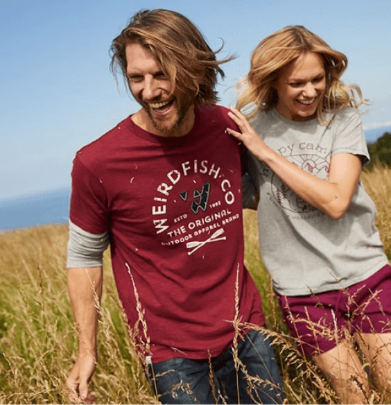 man and woman walking at the beach laughing wearing weird fish brand apparel
