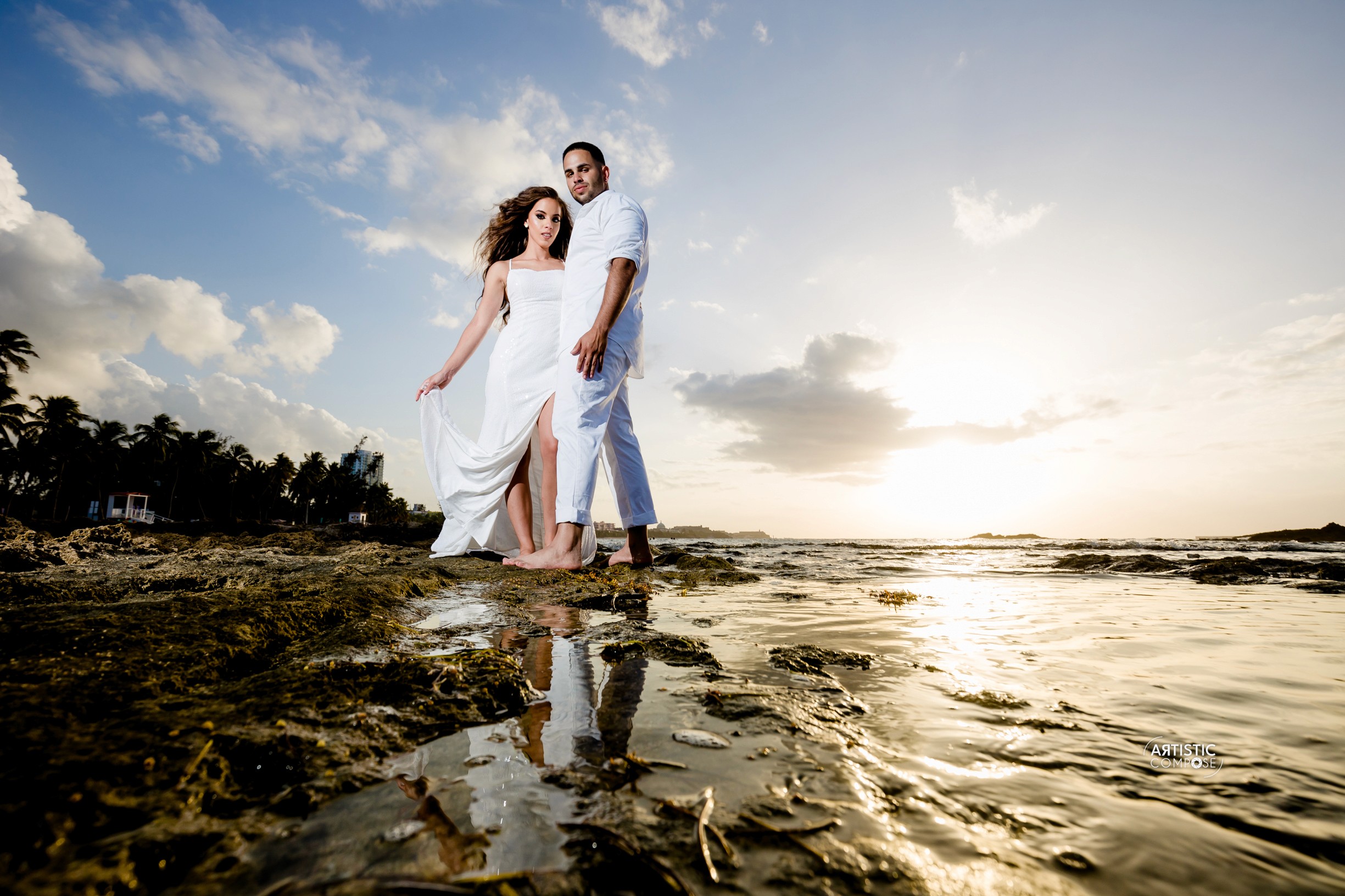 Three models standing in a wheat field, wearing beige suits.