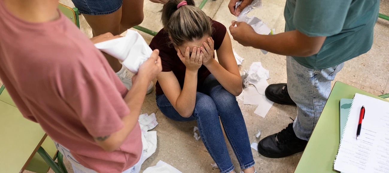 Enfants harcelant une fille au sol