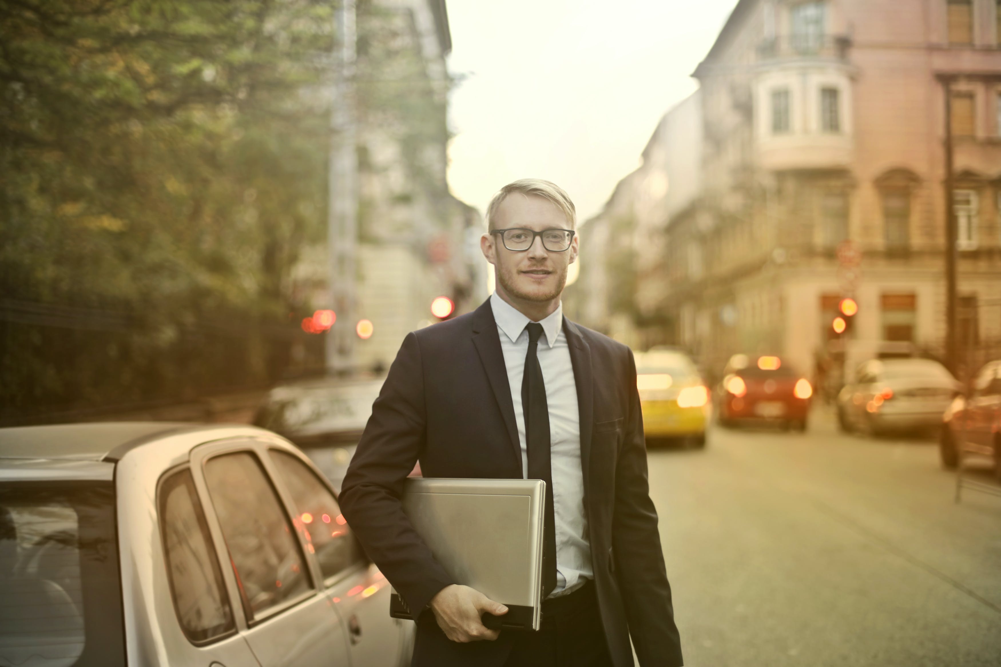 Smiling mortgage broker with laptop on street