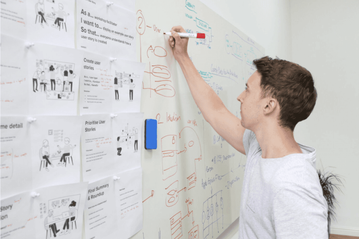 A designer drawing wireframes on a whiteboard