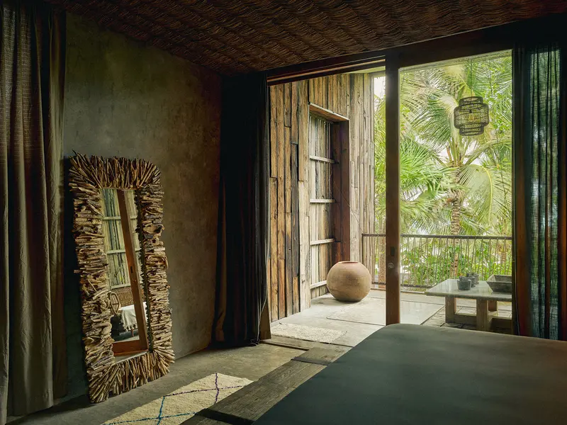 Oceanfront Suite at Be Tulum with architectural design, second-floor balcony, and relaxing seating area.