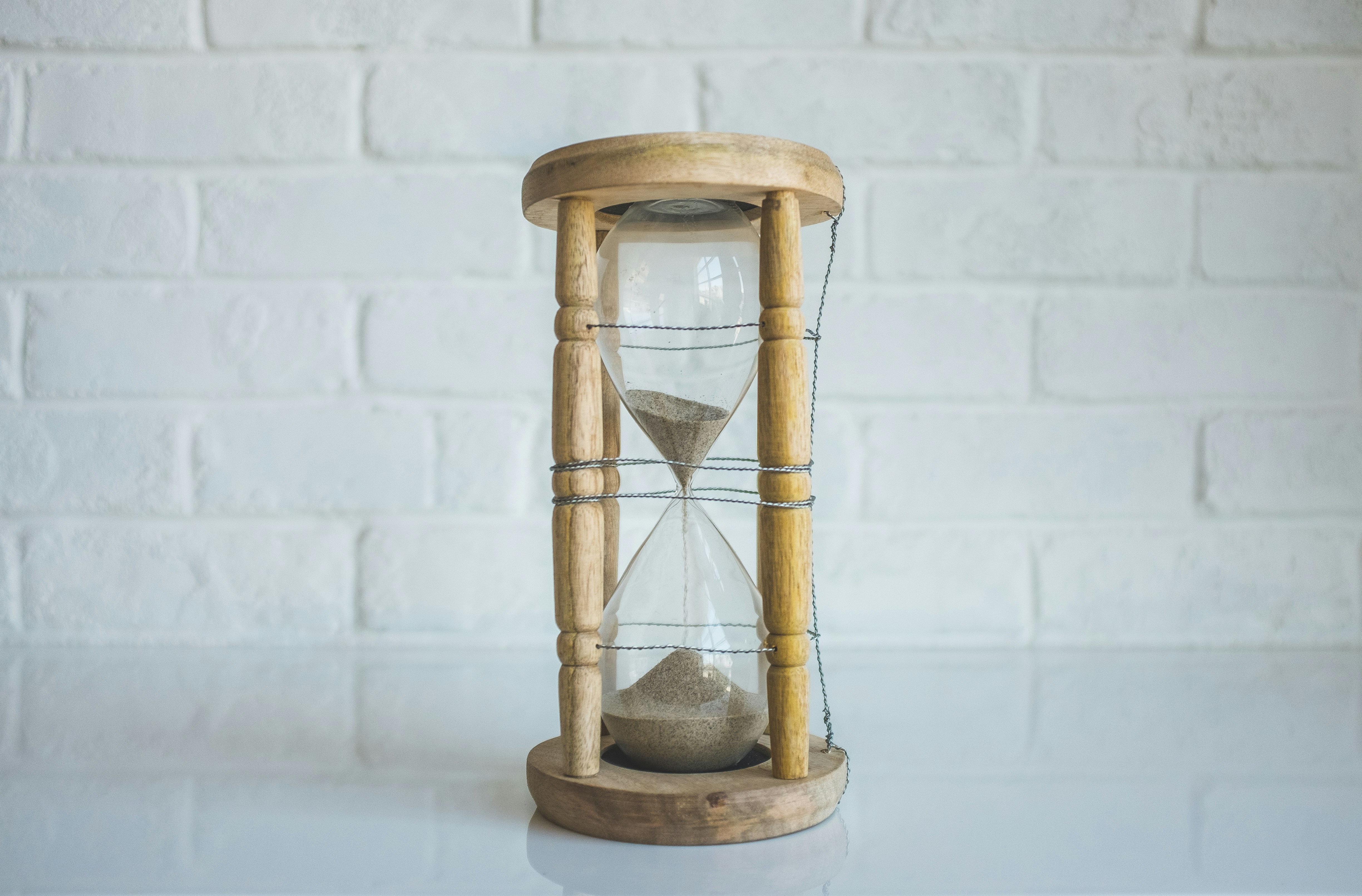 An hour glass which has nearly run out of pouring sand.