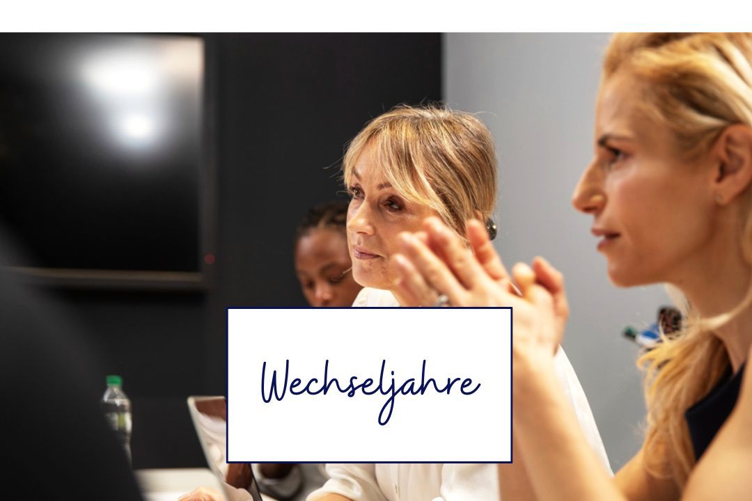 Berufstätige Frau um die 50 hört in einem Meeting aufmerksam zu
