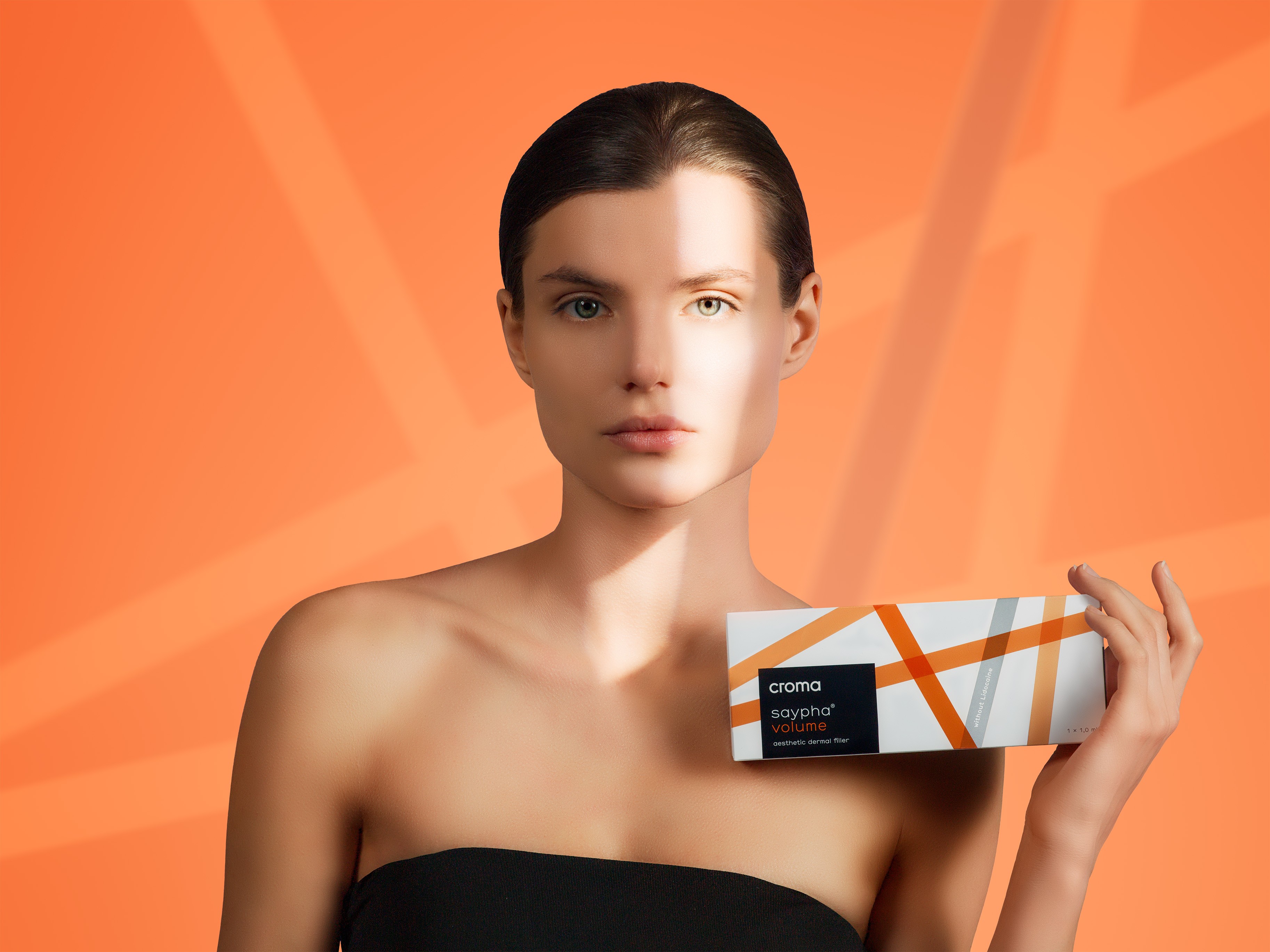 Croma Saypha Volume Lidocaine dermal filler product box held by model Canada with orange background
