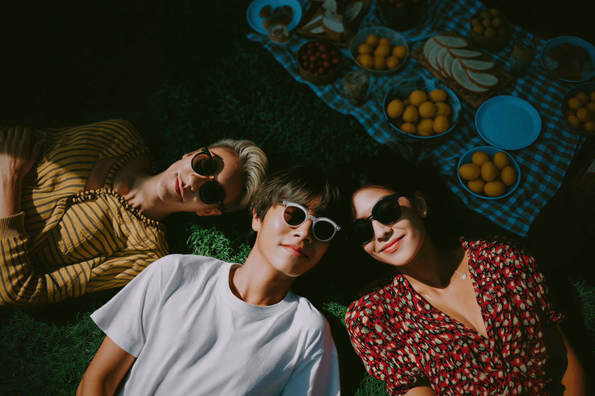 Friends lying on grass outdoors looking up at the sky