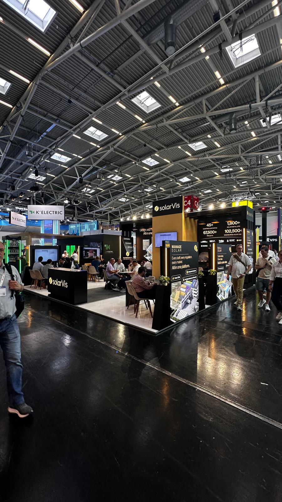 Client meeting area at the SolarVis stand, equipped with a 55‑inch screen for live platform demonstrations.