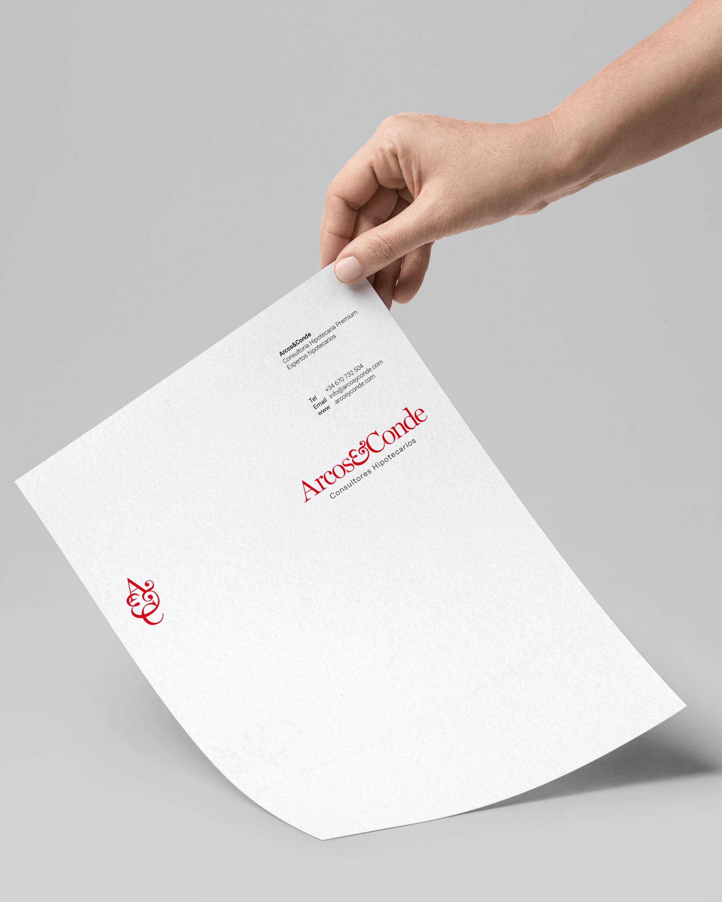 Hand holding an Arcos & Conde letterhead, brand identity design by Sebastian Saavedra