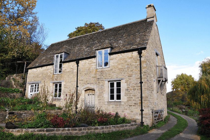 Modern living room with abstract art, beige sectional sofa, indoor plants, and large windows.