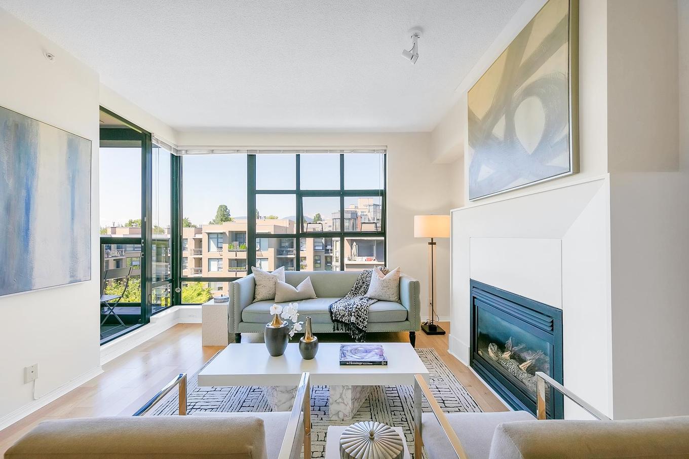 Modern living room with large windows, minimalist decor, and a fireplace, offering a bright and airy atmosphere.