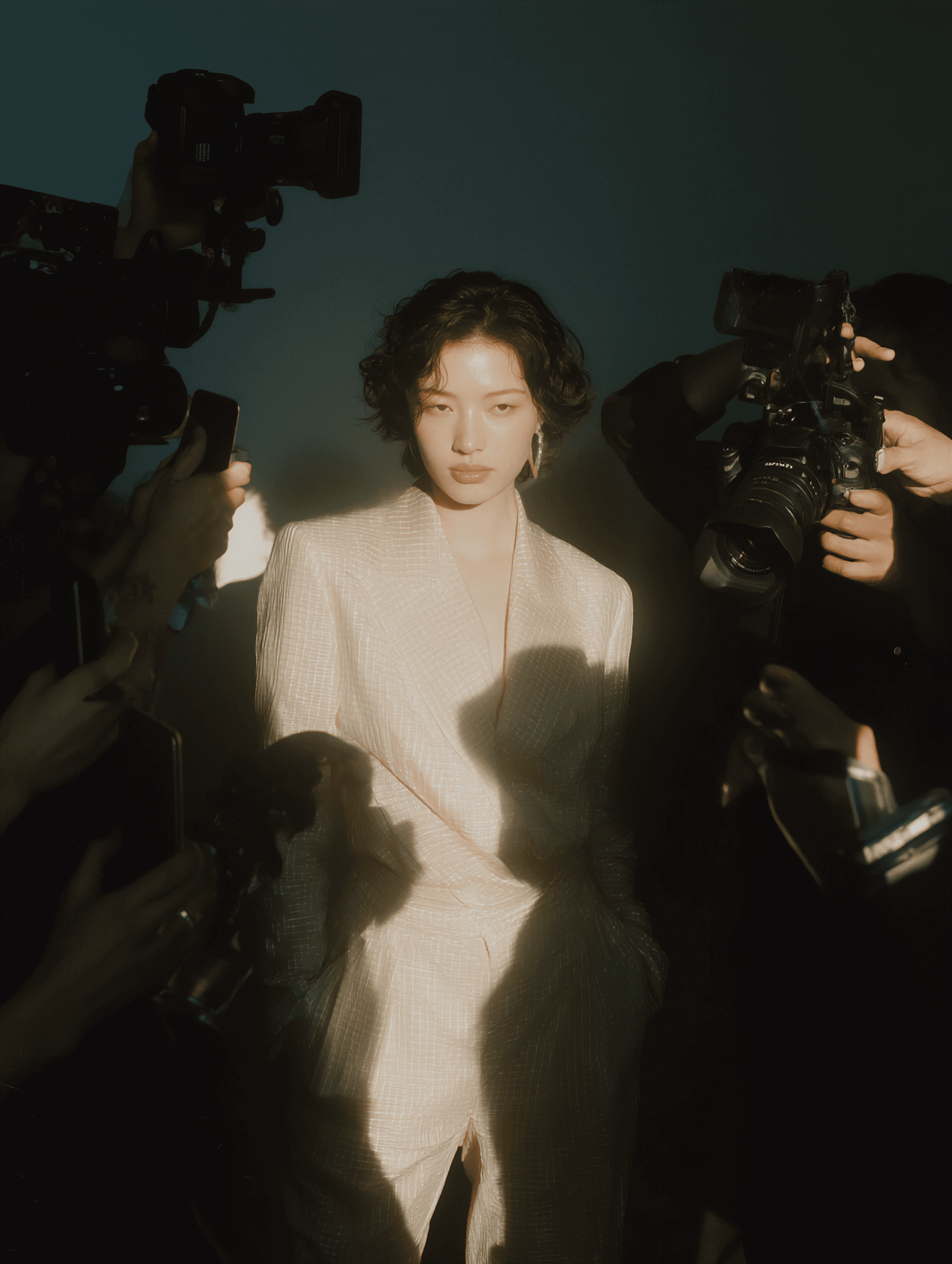 A model surrounded by photographers holding cameras