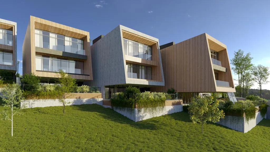 Modern villas with wood cladding on a sloped green hill.