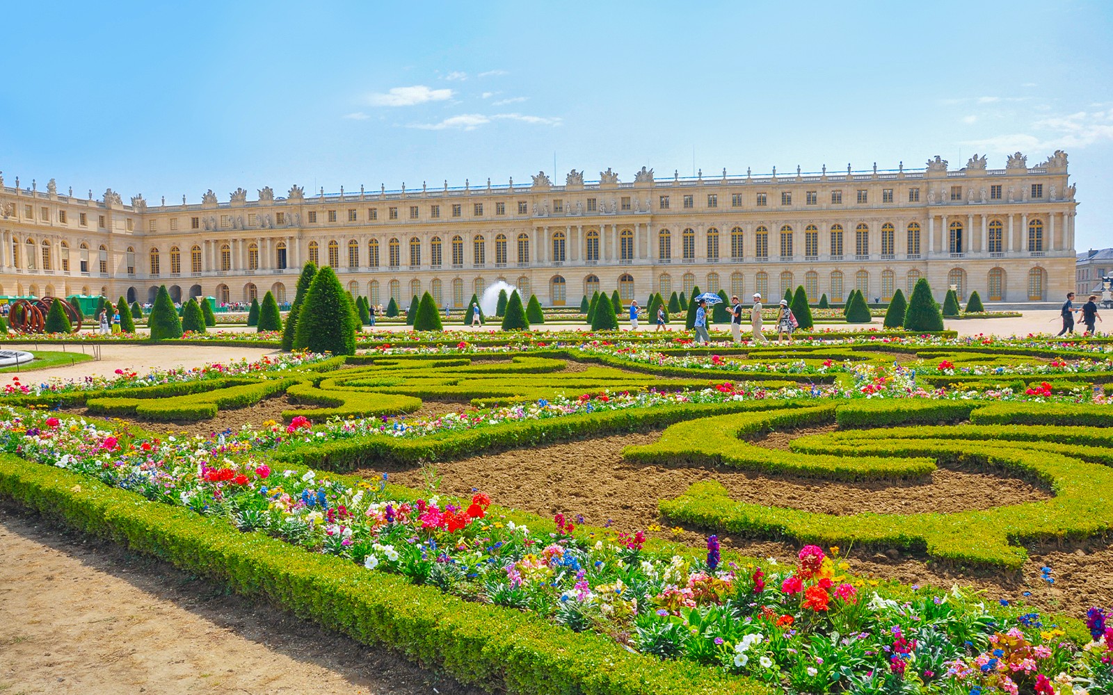 Slottet i Versailles med en levende blomsterhave i forgrunden, Frankrig.