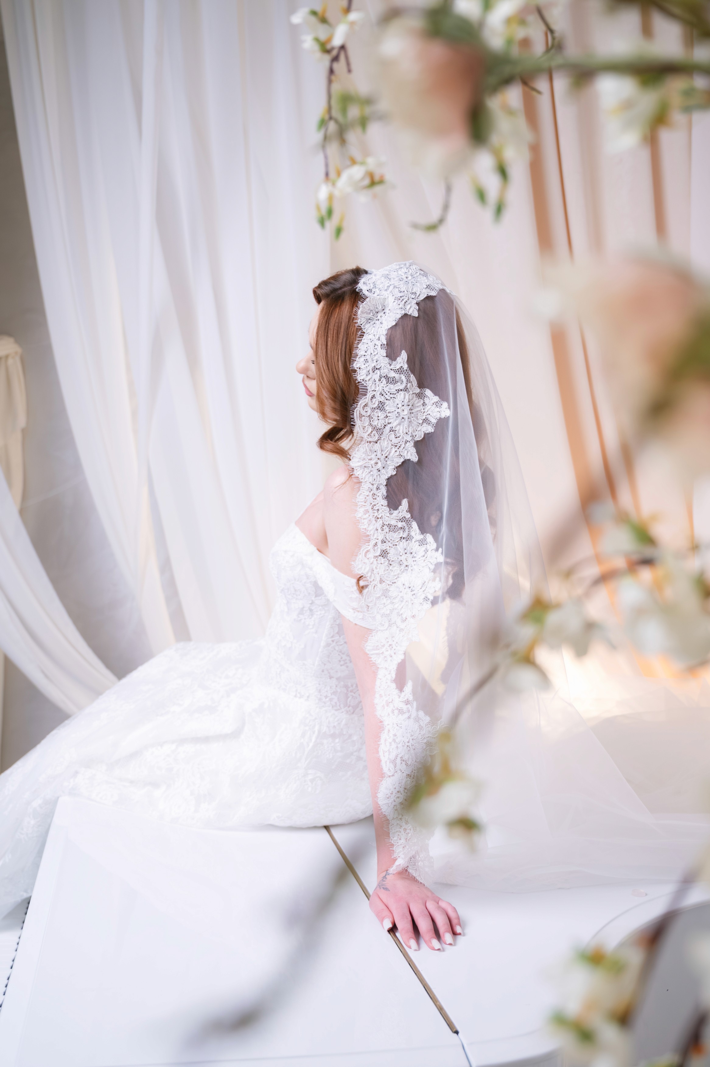 Mireasă pozând într-un decor romantic cu flori blurate în prim-plan, ședință foto bridal în București