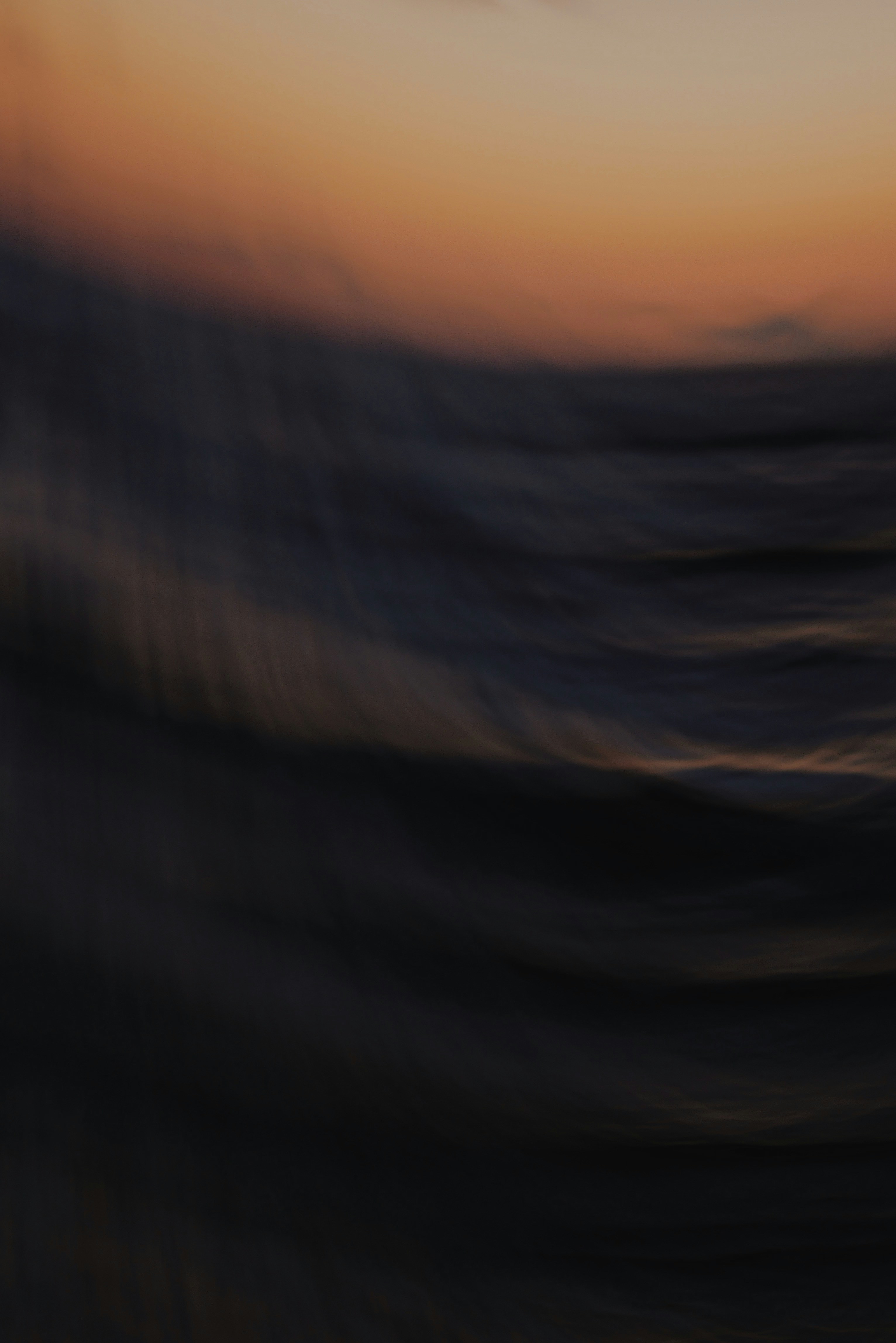 A blurry photo of the sun setting over the ocean