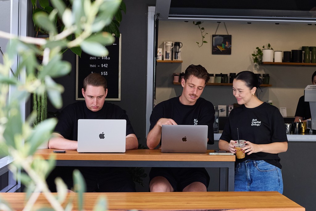 The team working together at a table with laptops, discussing business strategies or projects.