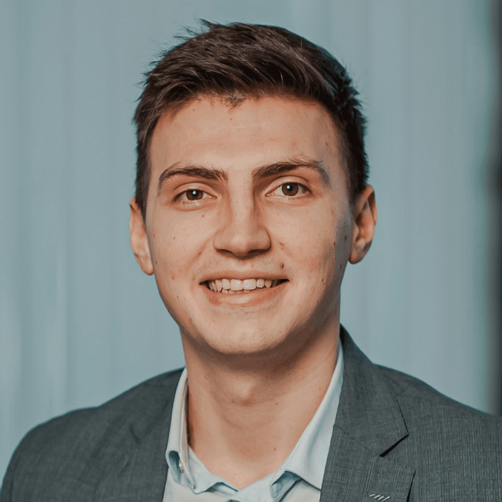 man in gray suit jacket smiling