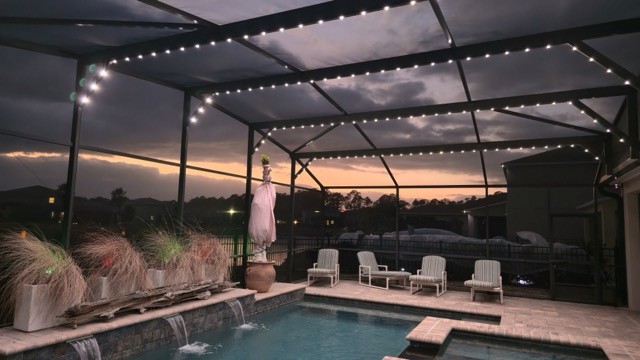 Lanai lighting design enhancing outdoor seating and pool area at dusk