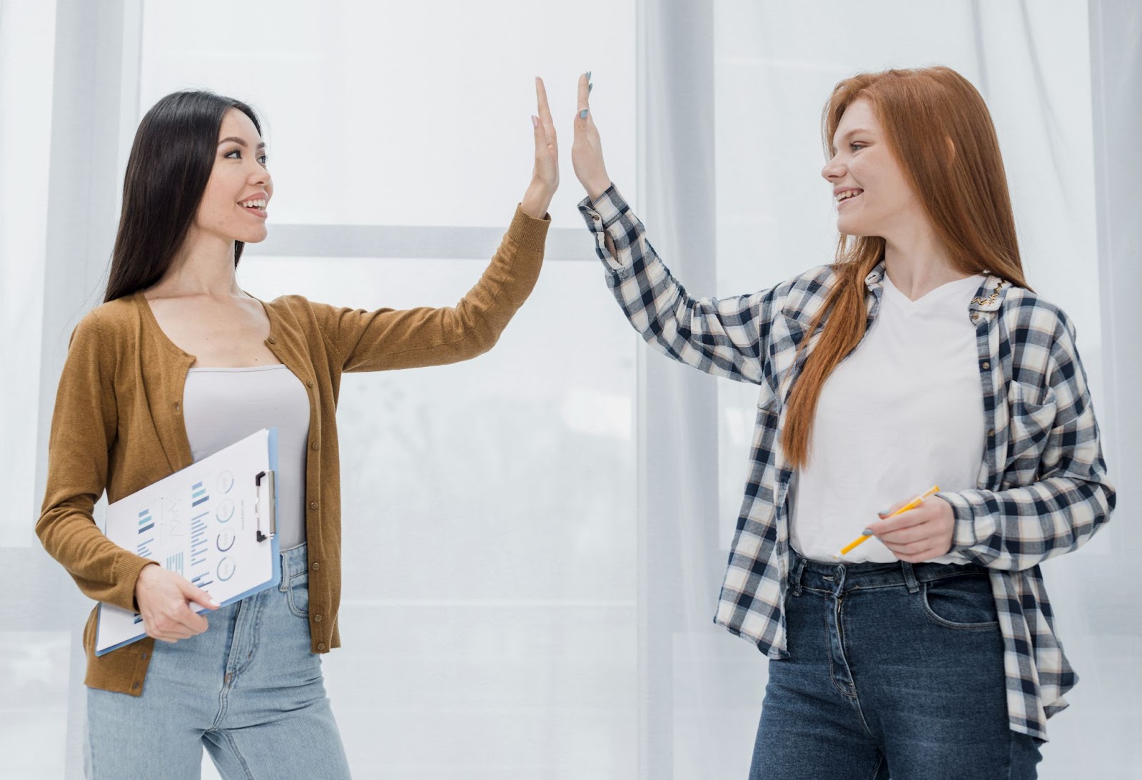 Two women exchanging a high five at a networking event