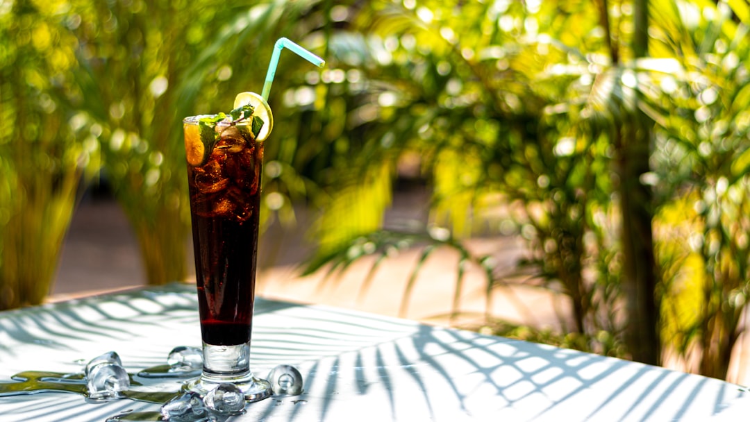 a glass of soda with a straw and a lime on a table