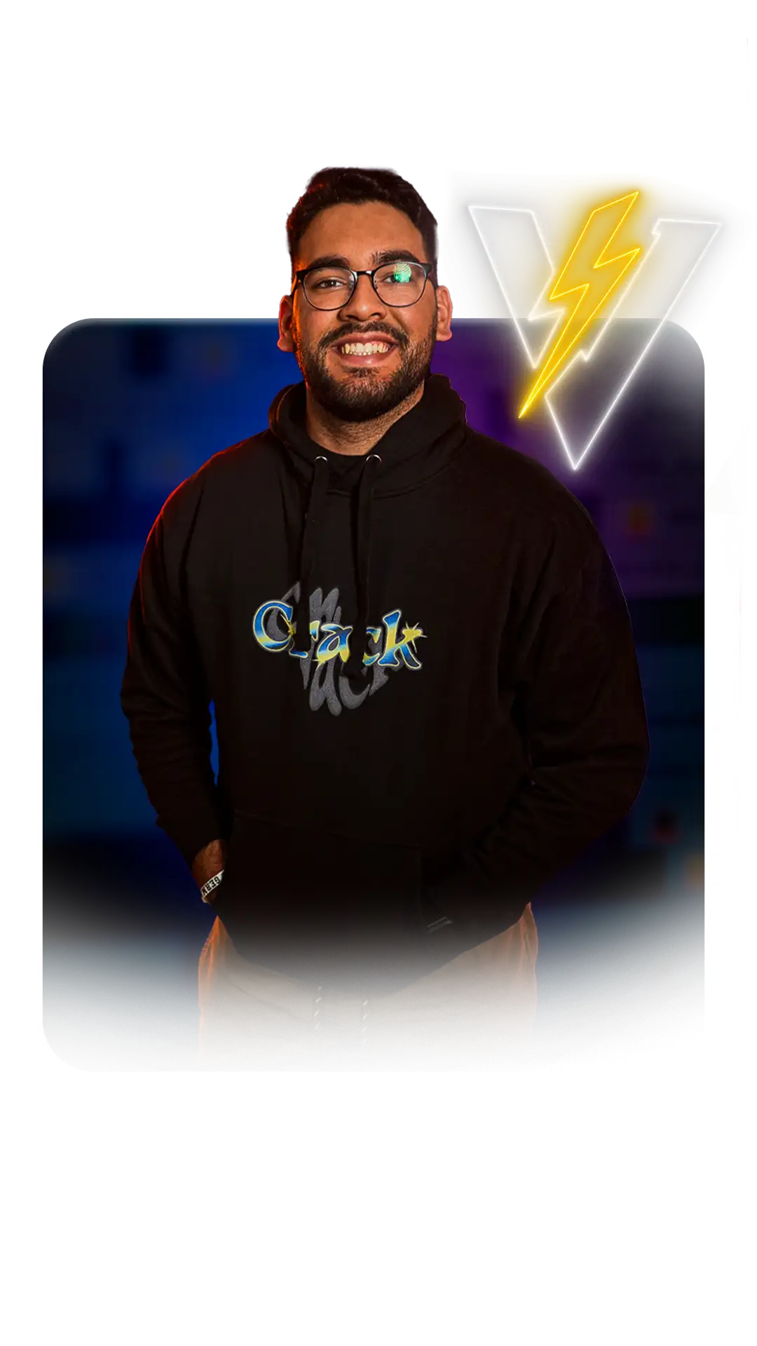 Man in glasses smiles, wearing black hoodie. Neon "V" lightning bolt graphic. Appears to be a streamer.