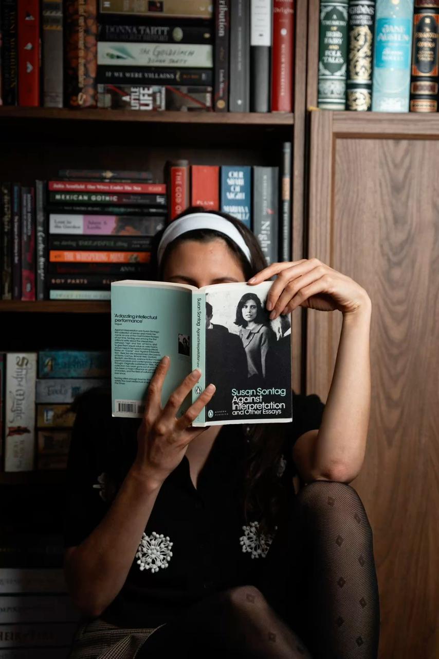 person holding pencil and stick note beside table