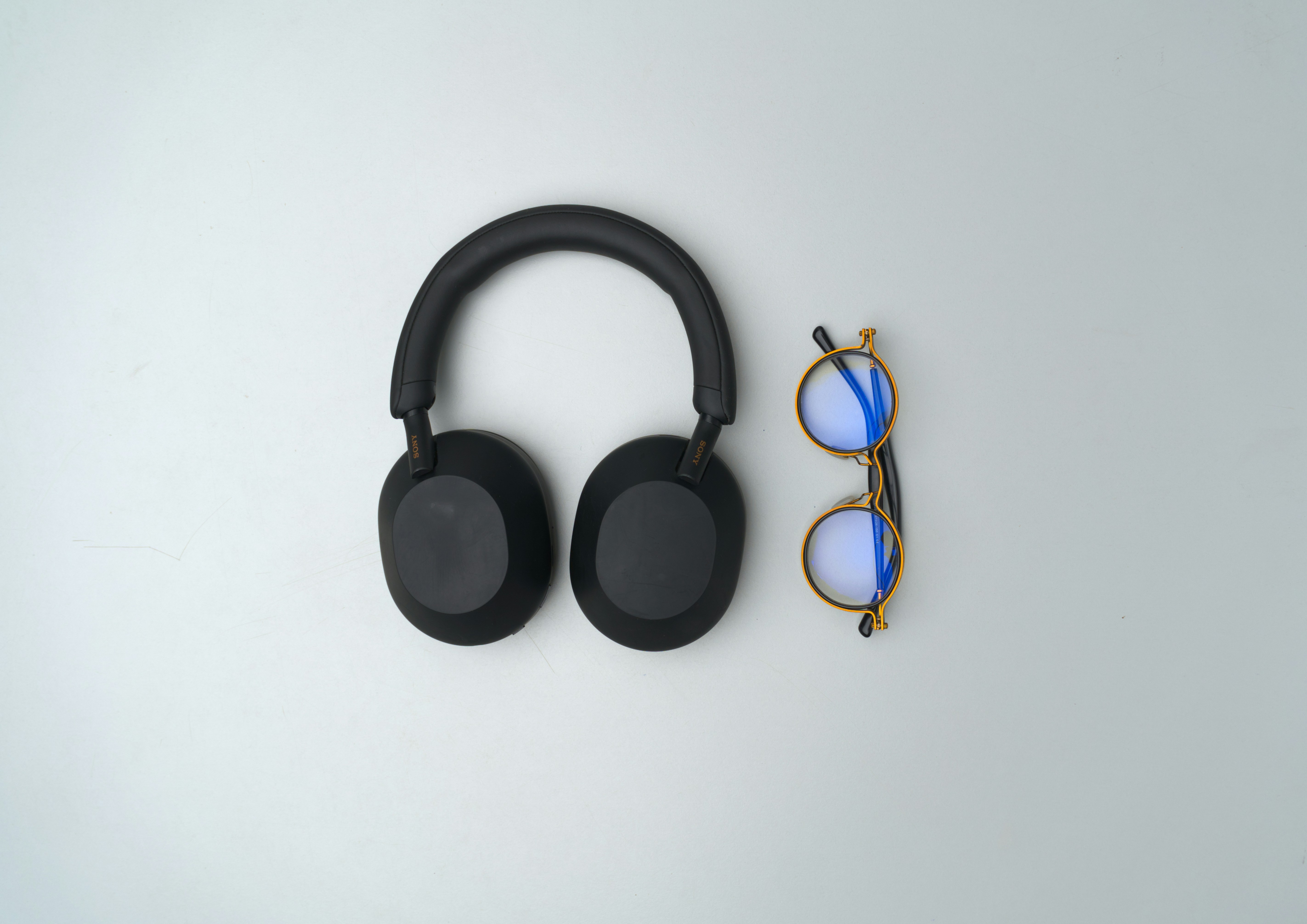 Black headphones and glasses on a light background