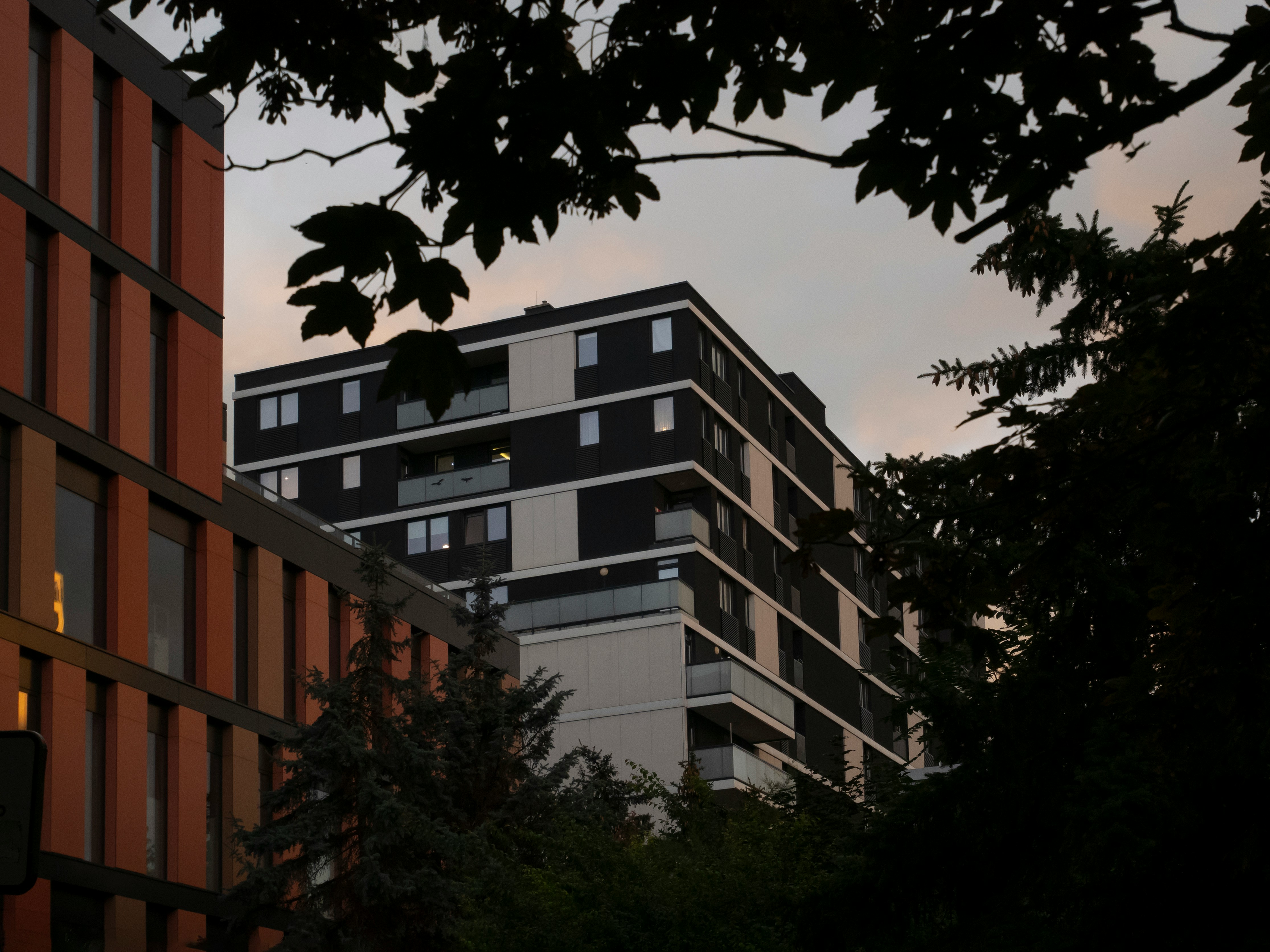 a tall building sitting next to a forest of trees