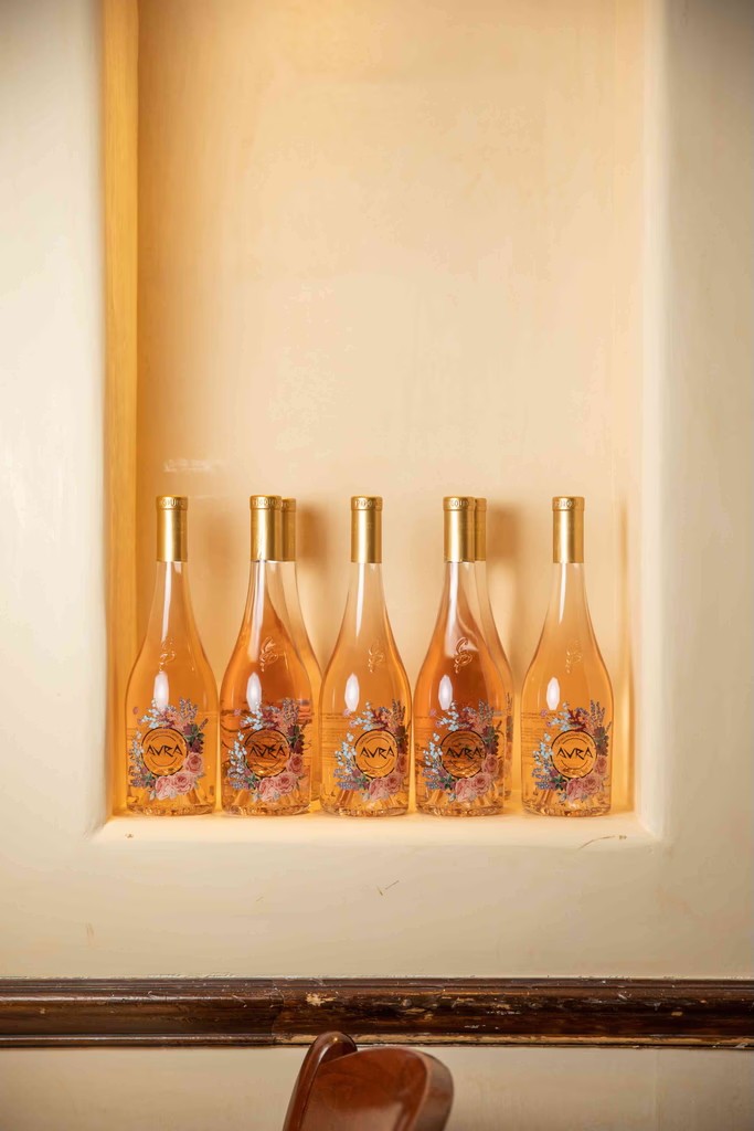 A simple interior scene featuring several wooden sculptures or decorative items displayed behind a light-colored backdrop.