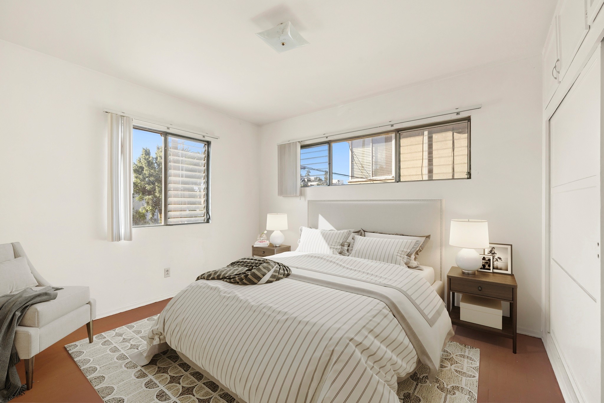 Bedroom with staged bed, natural light, and clean interior finishes at 436 Normandie Pl.
