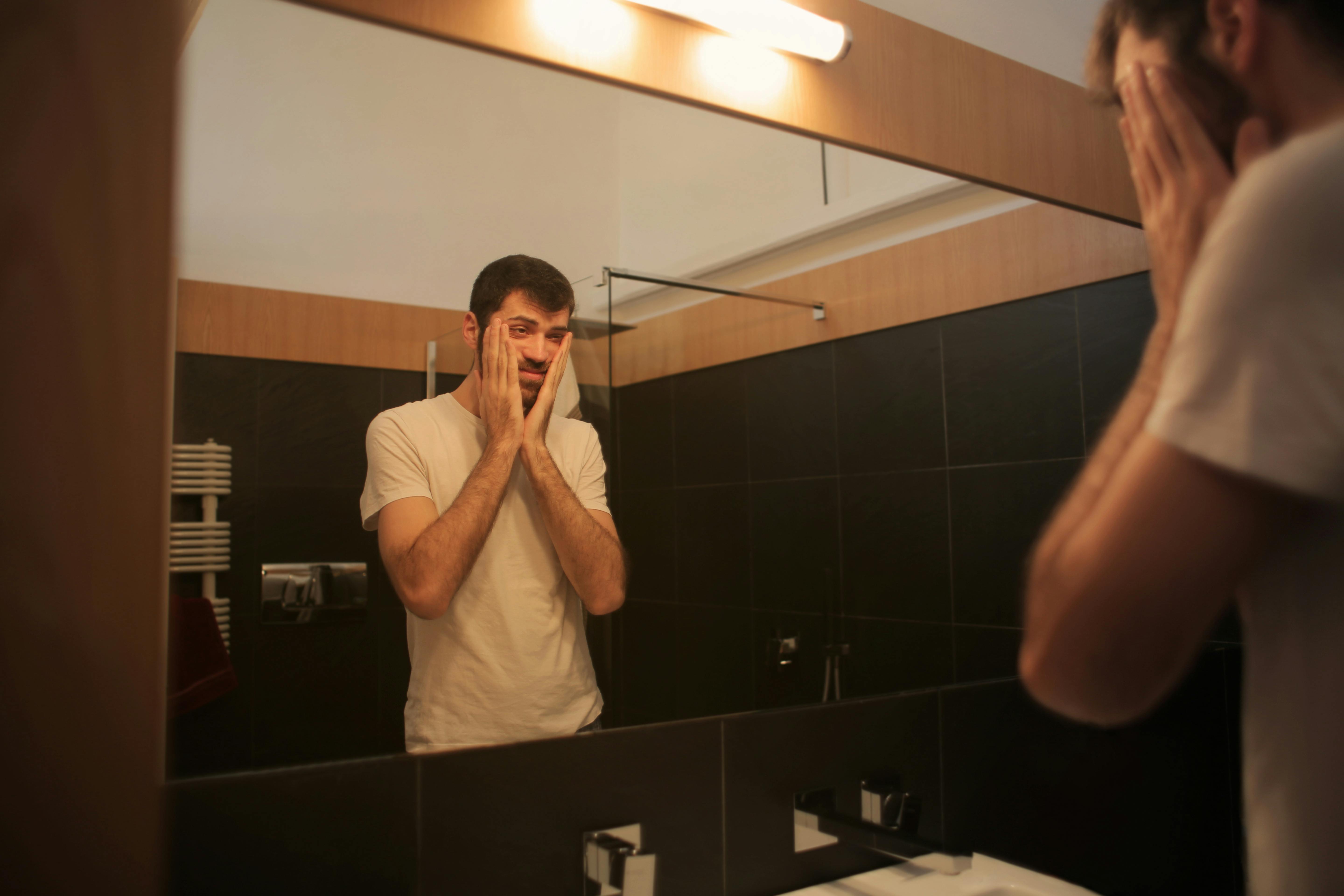 Man in bathroom staring in mirror