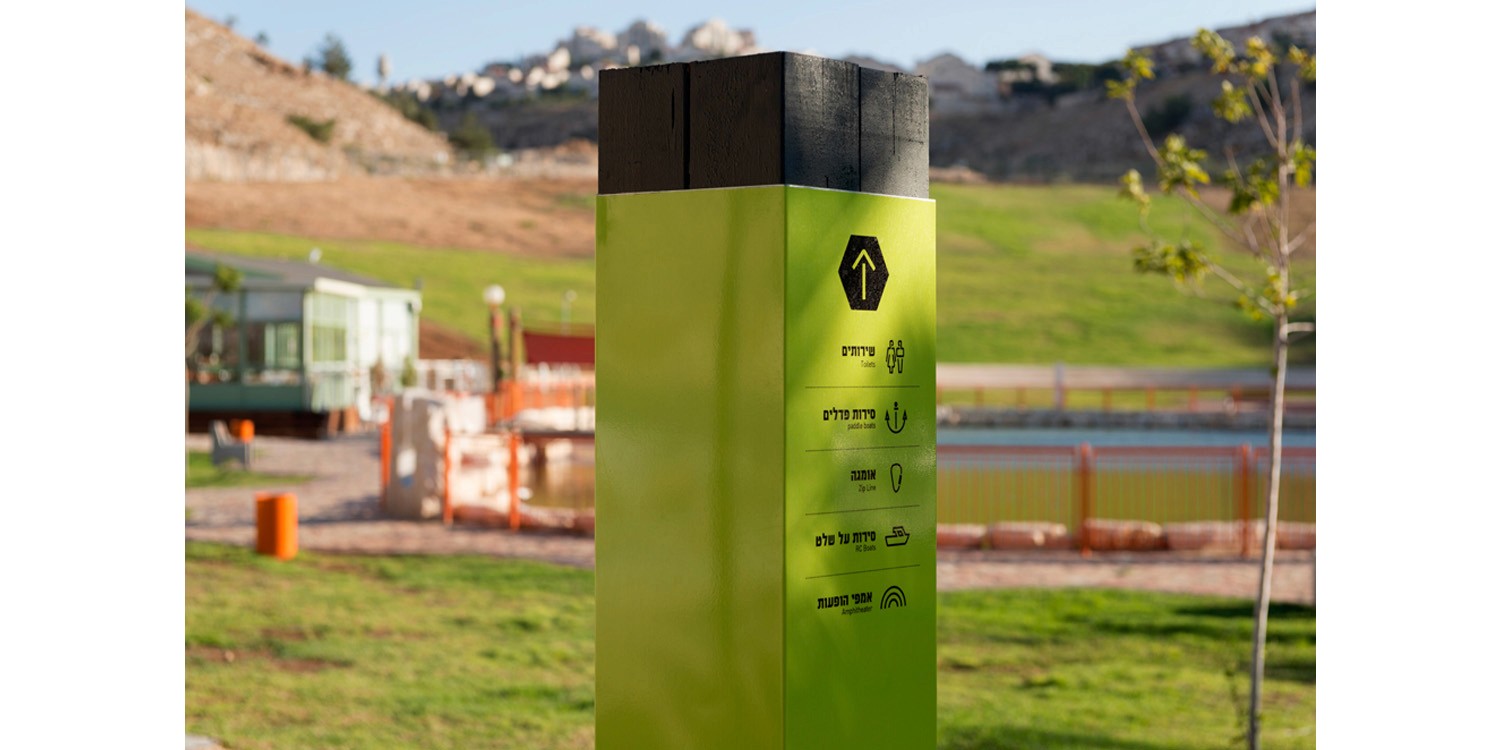 דלפק קבלה מעוצב עם אלמנט מיתוג ייחודי על רקע קיר אבן – עיצוב קונספטואלי למשרדים