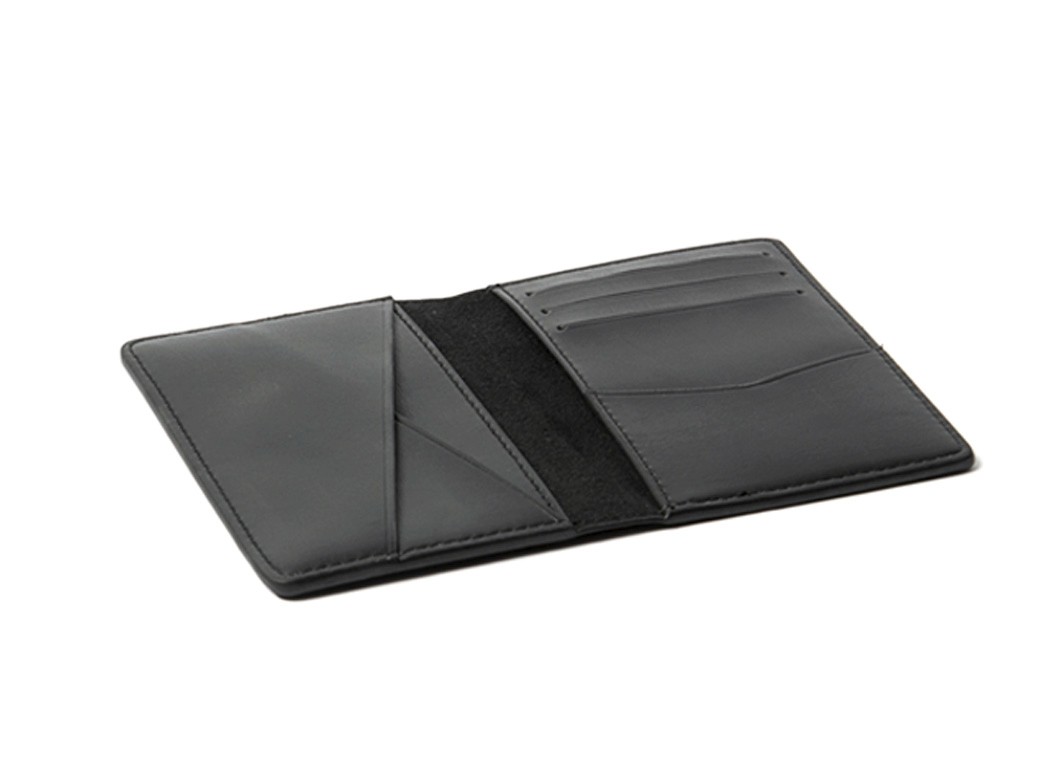 An open black leather wallet lying flat, displaying card slots on the right and an angular pocket on the left.