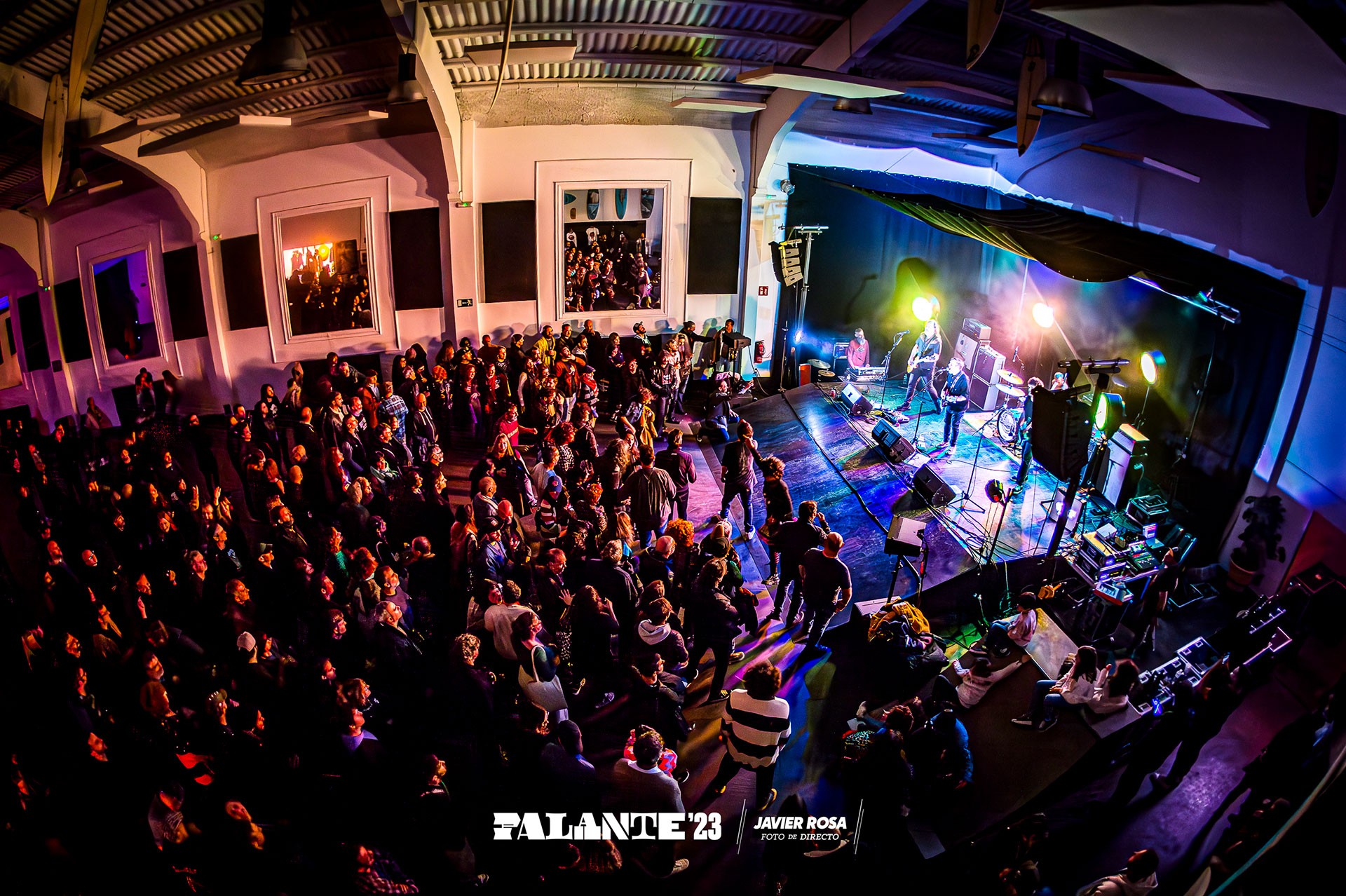 Cheerful, mature woman speaker with curly hair gesticulates warmly at an event.