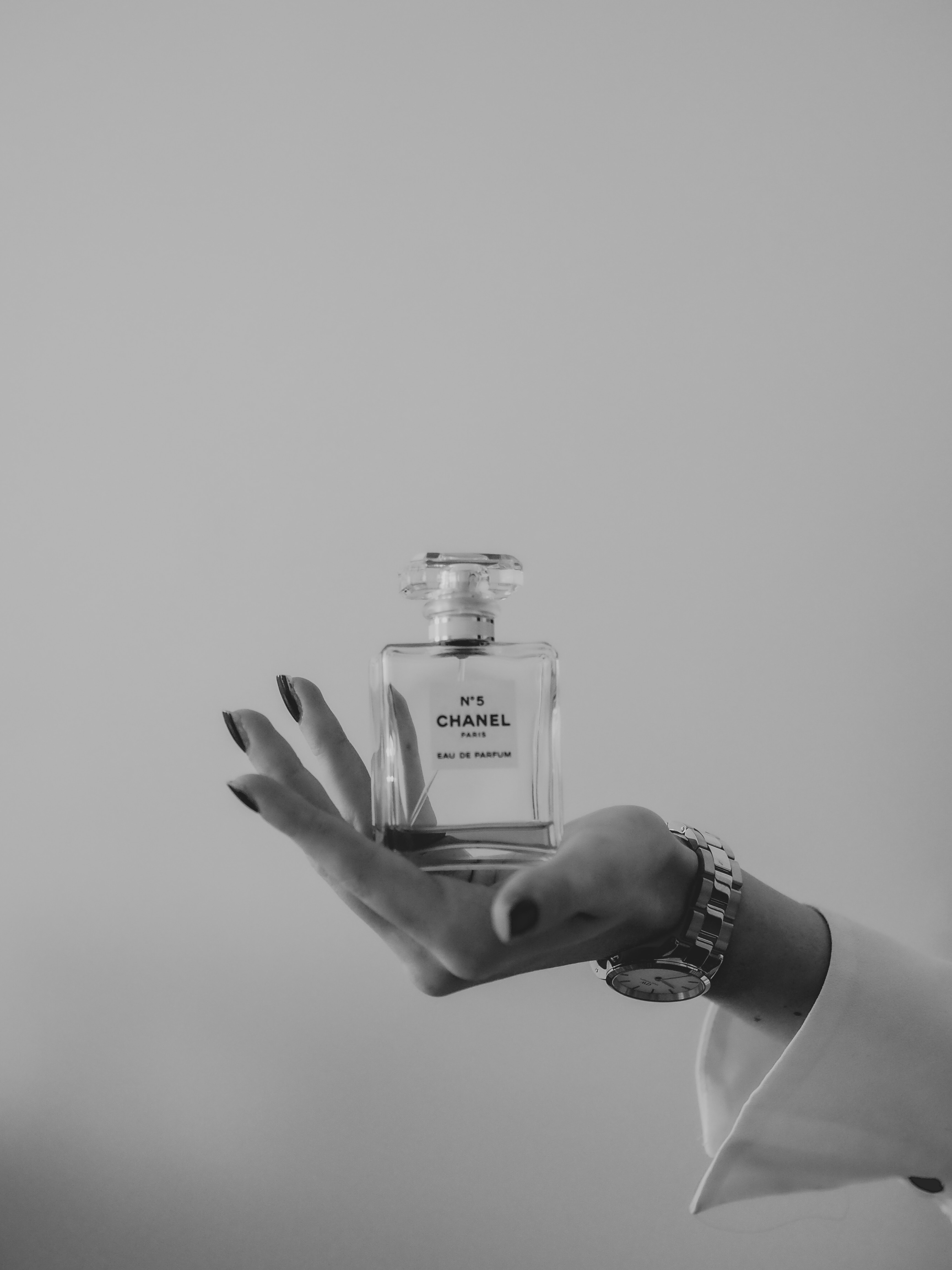 A hand holding a perfume