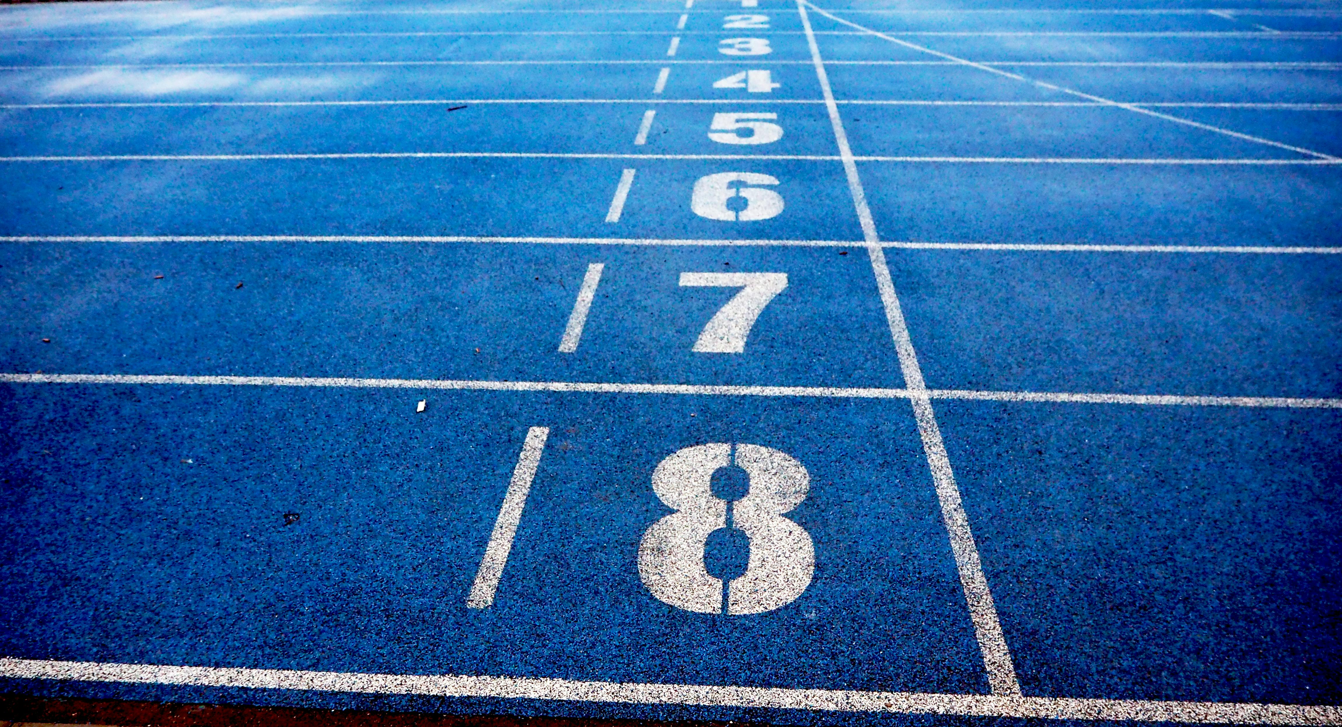 Blue running track lanes with white lane numbers