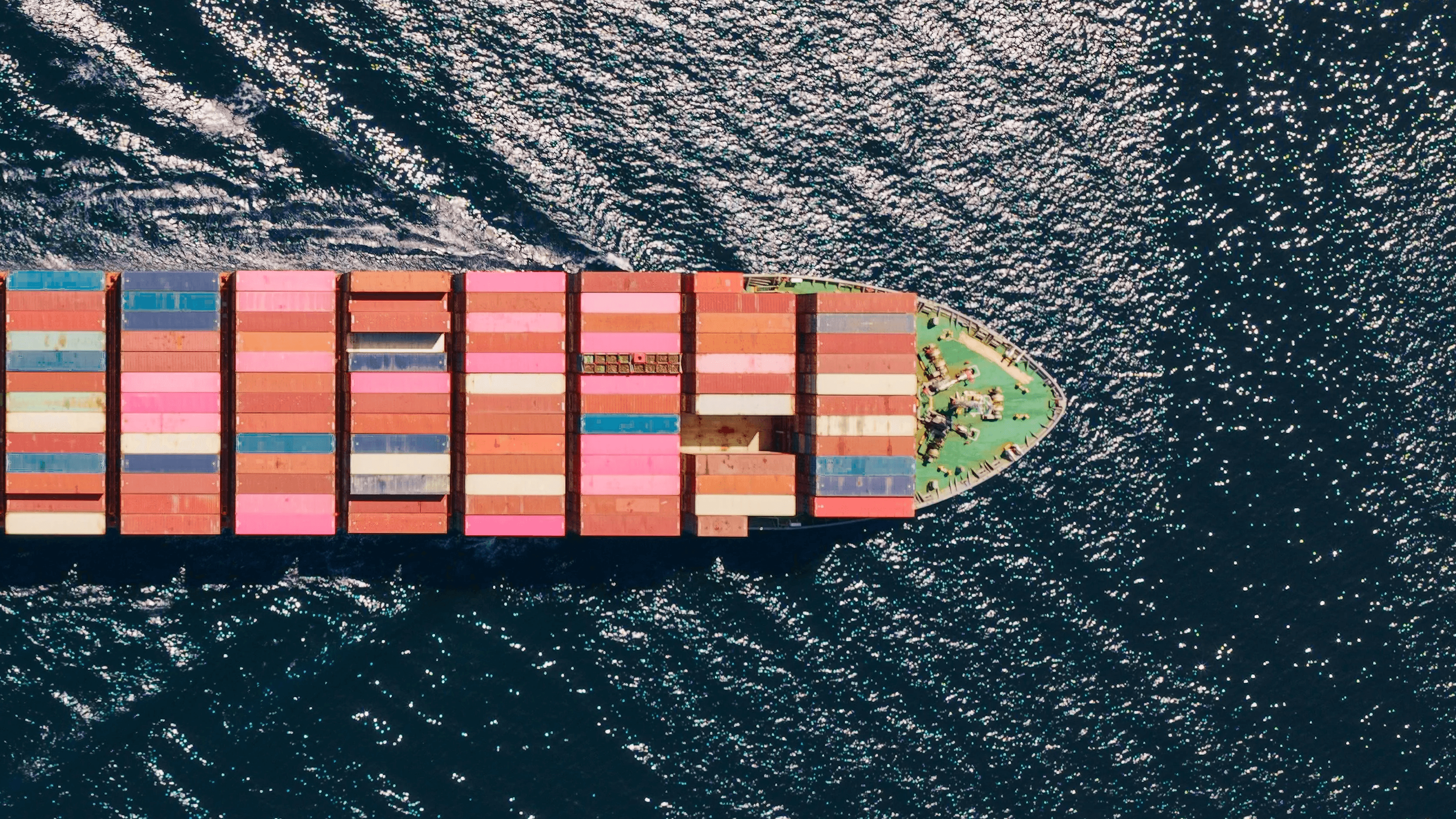 Vue aérienne d’un porte-conteneurs transportant des conteneurs colorés en mer.