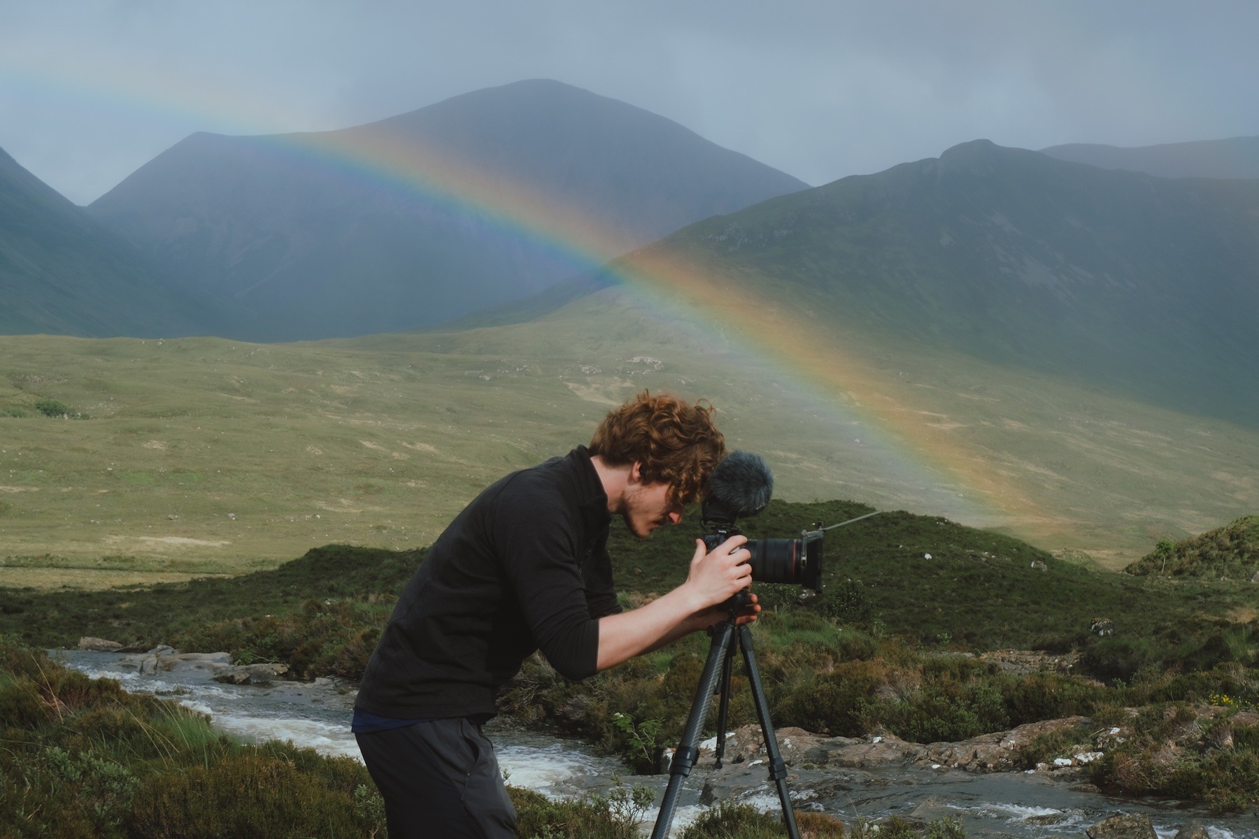 Founder setting up a camera and microphone in the mountains