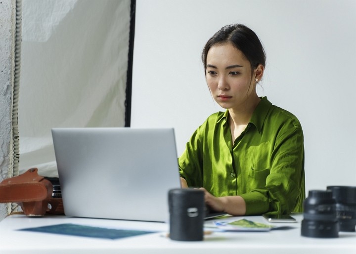 Business owner reviewing sustainability reporting information on a laptop