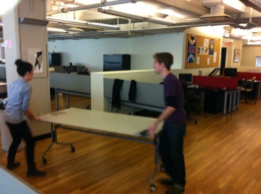 two persons moving a table