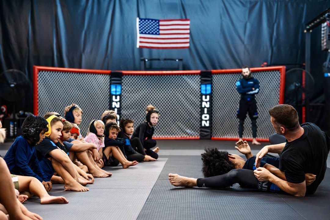Coach Nolan showing instruction on the mat for kids class  at Union Martial Arts
