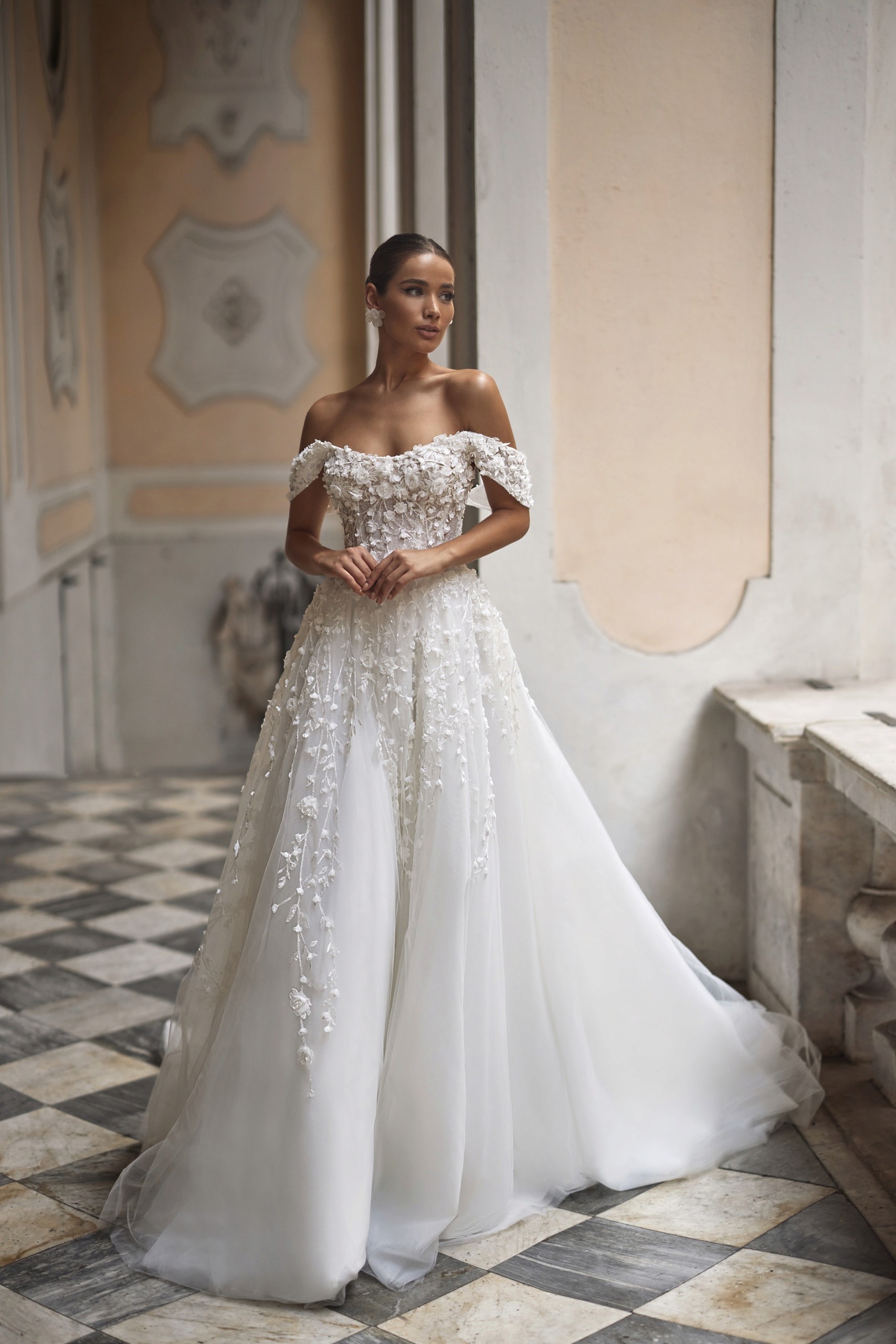 Eine Braut in einem verspielten Hochzeitskleid berät sich mit ihrer Stylistin.