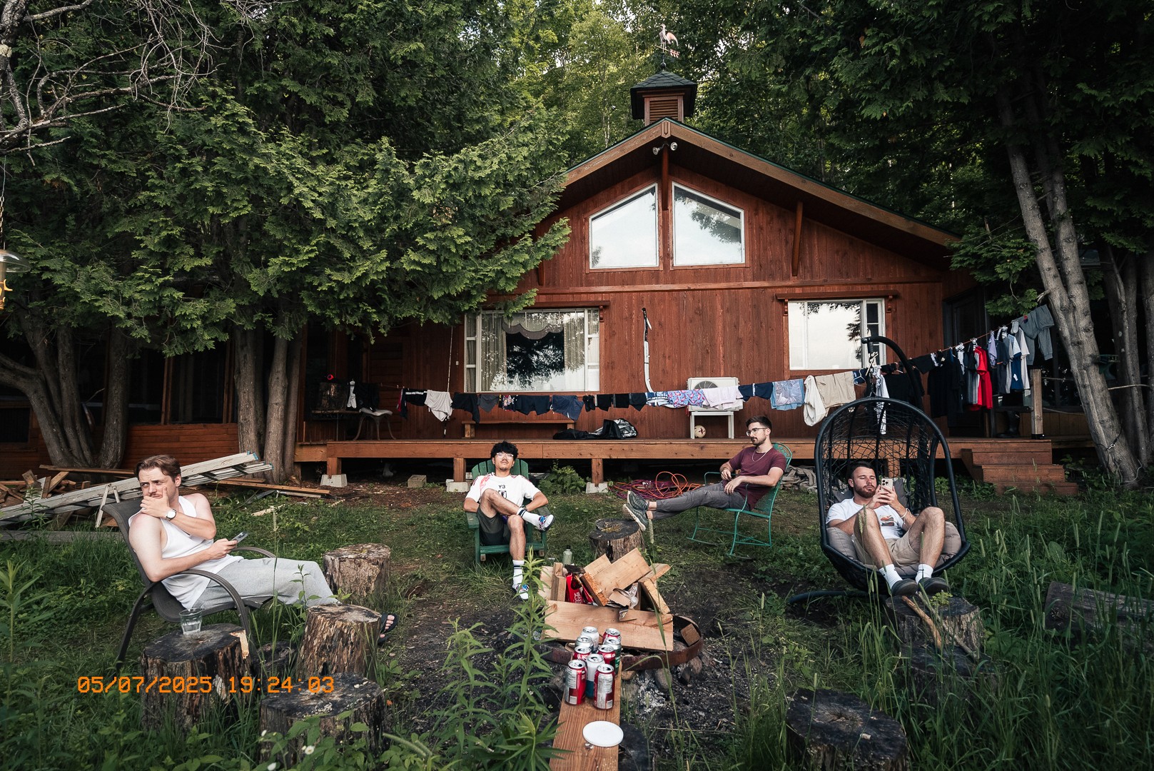 Groupe d’amis relaxant devant un chalet en bois.