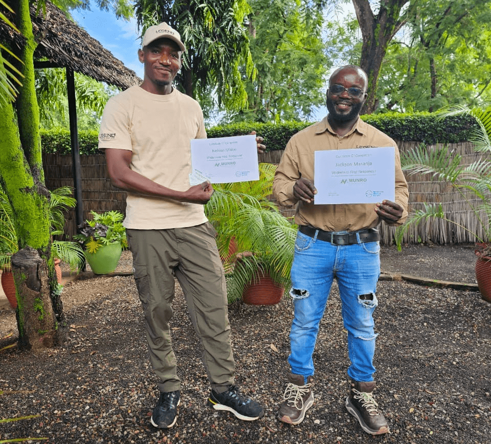 Legend Expeditions lead guides Nelson Mbise and Jackson Masanja holding their Wilderness First Responder certificates after completing the Munro Medical Solutions course in Moshi, Tanzania.